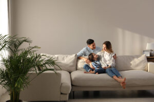 Family with little daughter resting on sofa in living room