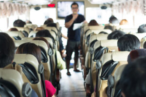 Selective focus image of Private bus with tourists and guided tour.