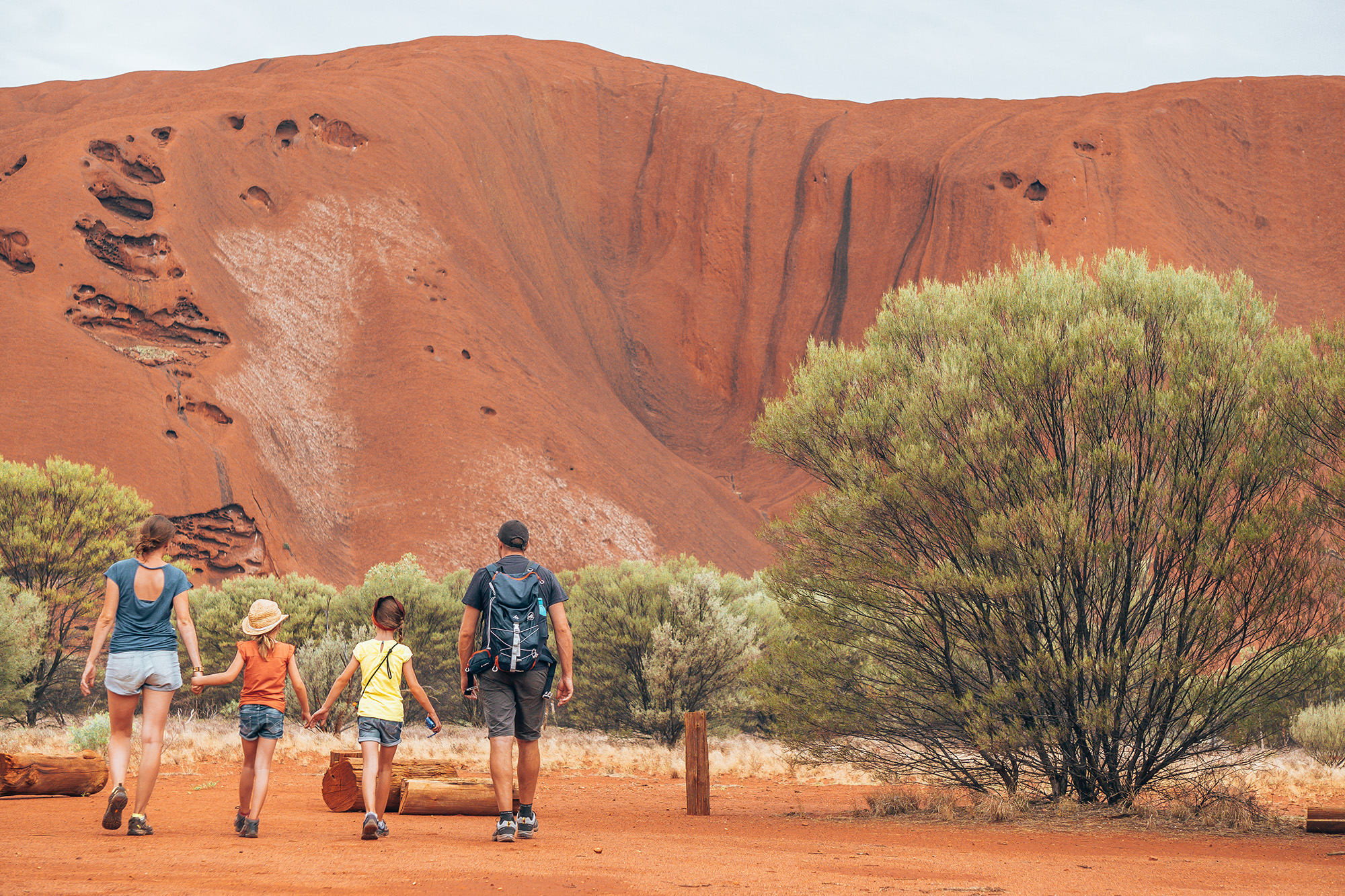A family walking through the Australian bush of the outback desert, the red centre of Australia